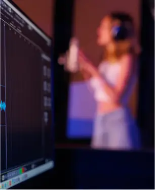 Donna che registra in studio con microfono e cuffie